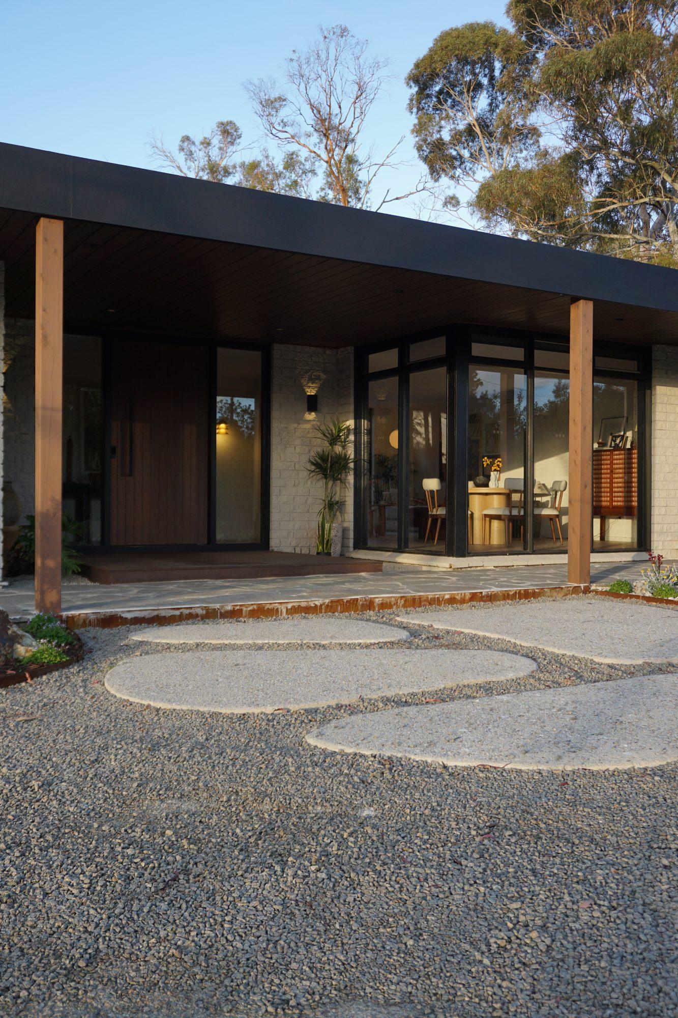 Finchwood House entry at dusk — timber posts, black roofline and zen gravel garden, Mount Eliza