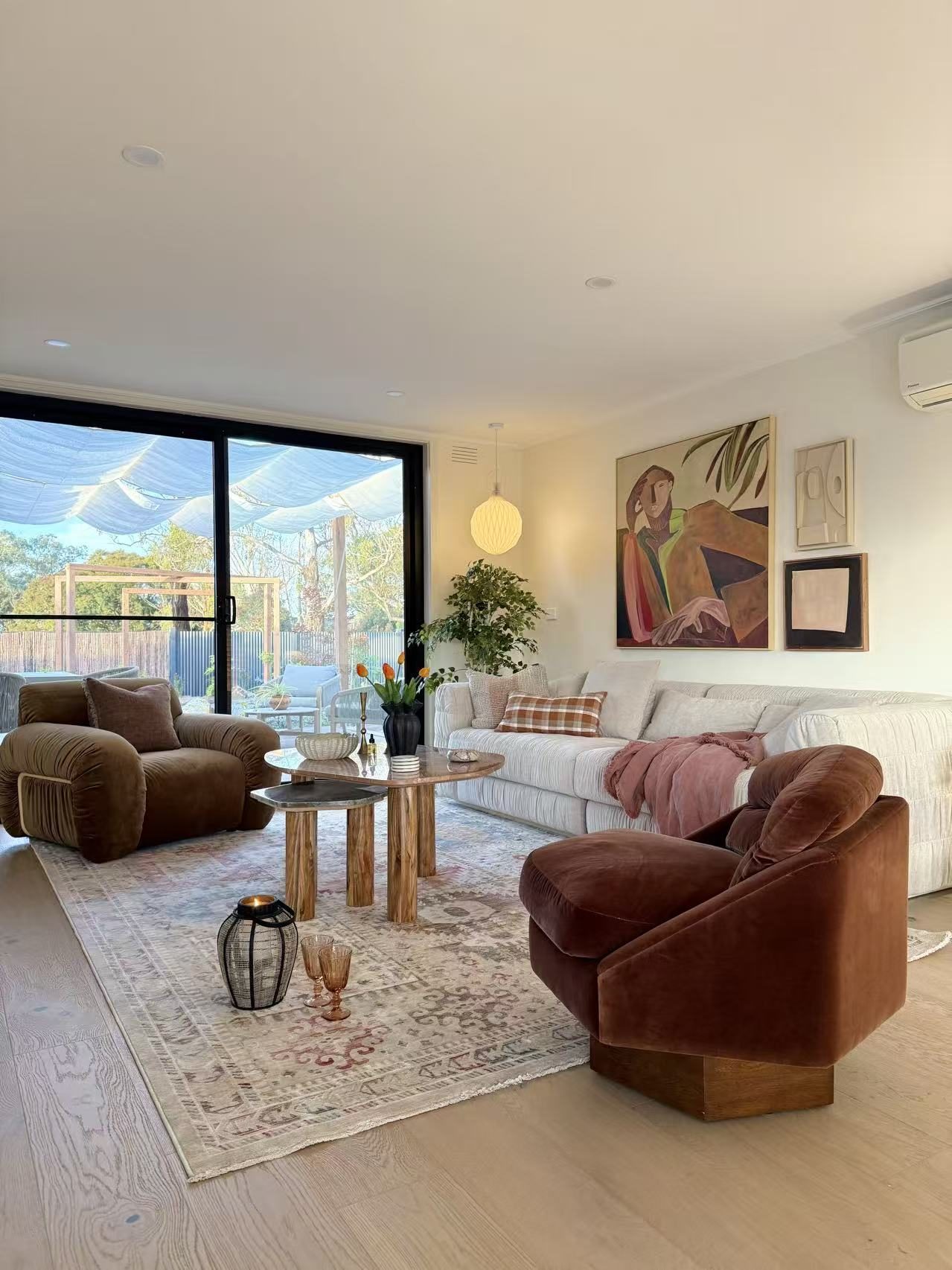 Finchwood House living room — velvet armchairs, travertine tables and vintage rug
